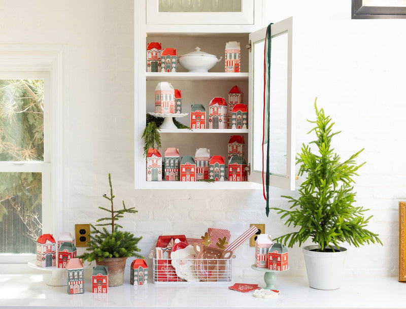 Christmas kitchen shelf display with reindeer and Santa plates alongside holiday boxes and greenery