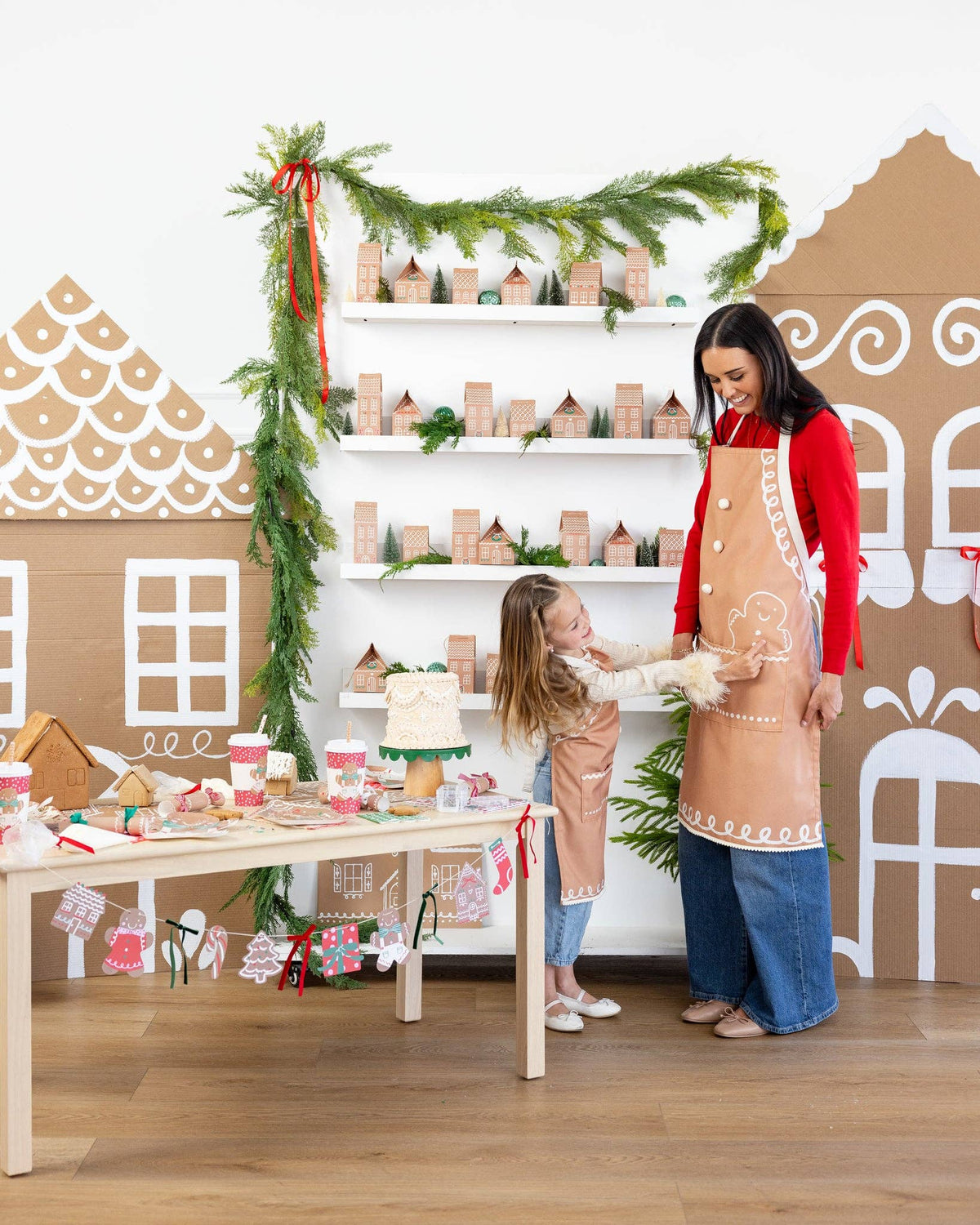 Matching Gingerbread Apron set for adult and child displayed together, highlighting the coordinated design for holiday baking.