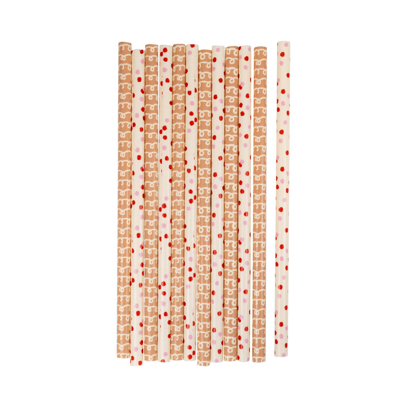 Close-up of reusable Gingerbread Straws arranged side by side in two patterns—gingerbread piping and red dots.