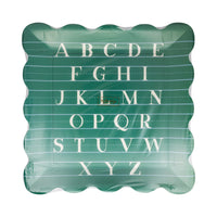 Front view of green alphabet paper plate with scalloped edges and white A-Z lettering on lined paper background