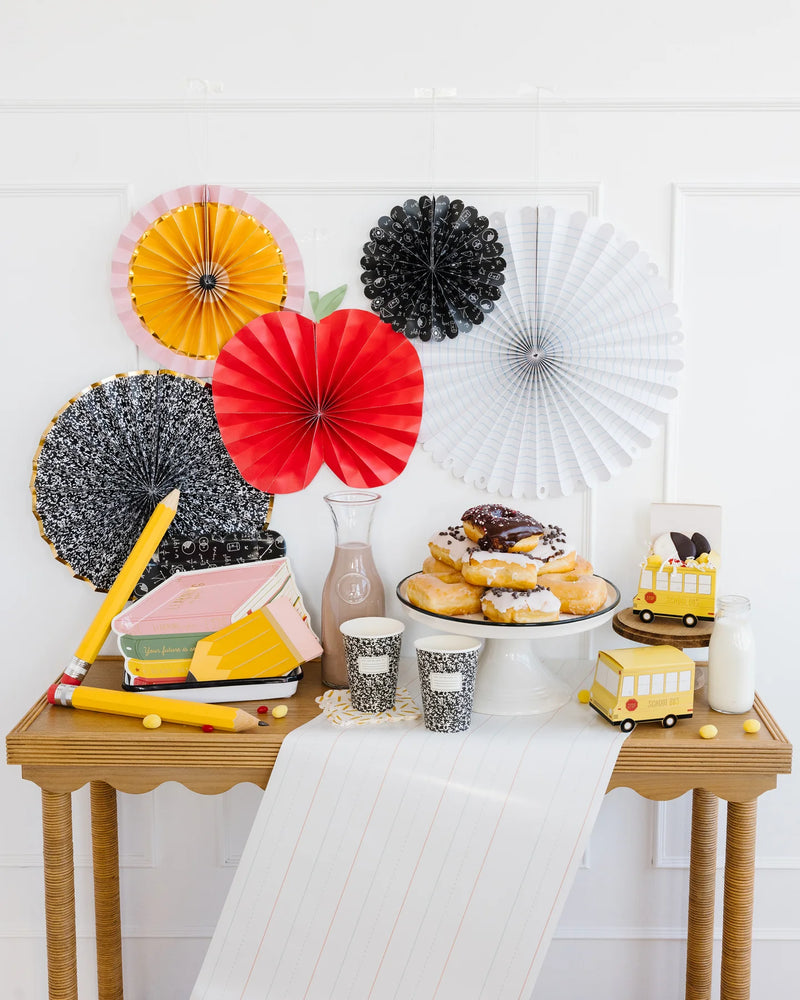 School-themed snack table featuring the writing paper table runner, notebooks, pencils, and pastries