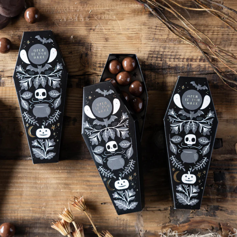 Group of Halloween Coffin Treat Boxes with spooky gold foil designs filled with chocolates.
