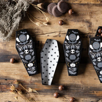 Open Coffin Treat Box with star-patterned interior filled with candy on a rustic table.