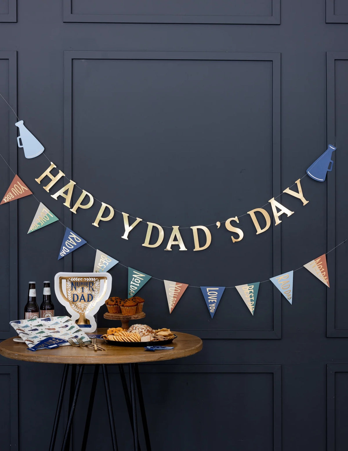 A Father's Day party setup featuring the Number 1 Dad Trophy Plate on a table with themed decorations and snacks.