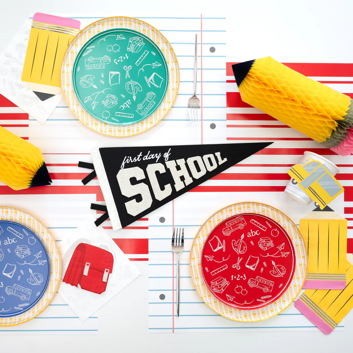 Backpack napkins on yellow striped runner with white icons.