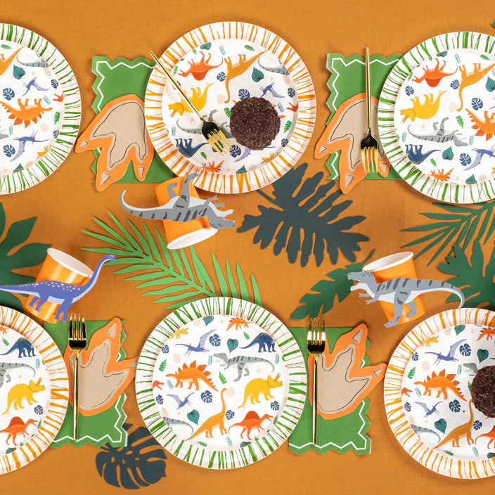 Overhead dino party table with multiple footprint napkins at each setting.