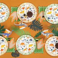 Overhead dino party table with multiple footprint napkins at each setting.