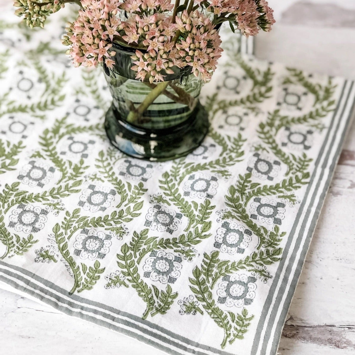 A sage green tablecloth with a floral print perfect for Easter and Spring