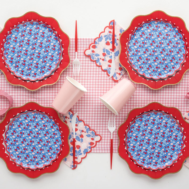 strawberry paper napkins on a red and white table setting