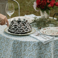 A sage green tablecloth with a floral print perfect for Easter and Spring