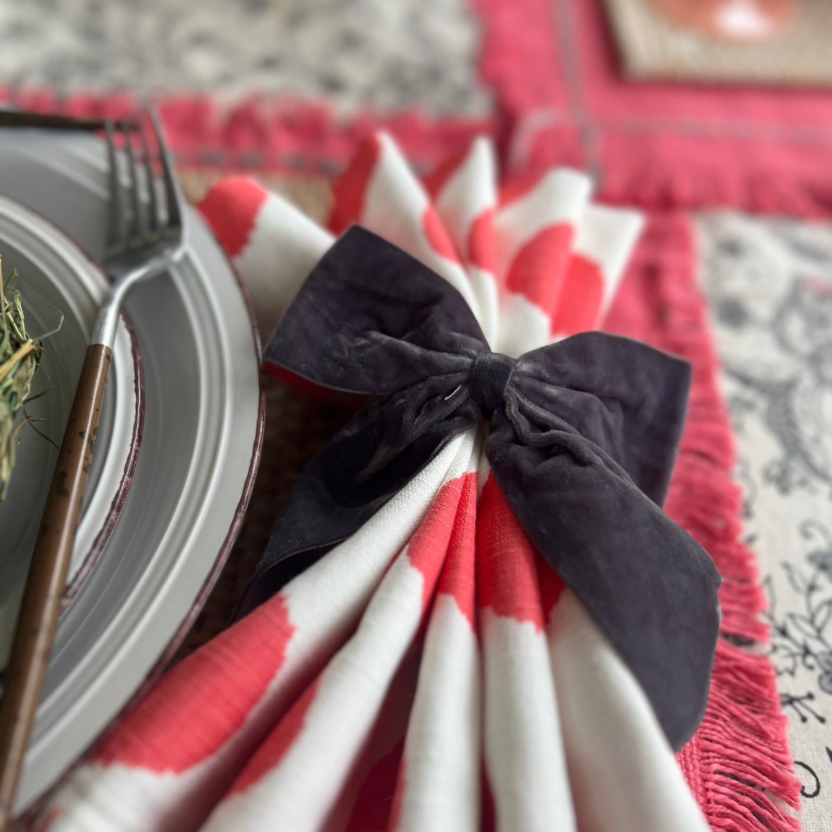 Gray velvet bow napkin rings on a spring napkin.