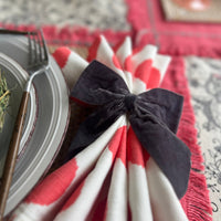 Gray velvet bow napkin rings on a spring napkin.