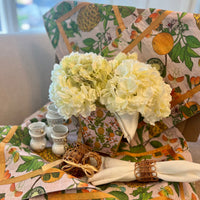 Transform your table setting with our Pineapple Garden Enameled Rectangle Placemats. This set of four summer placemats, crafted from textured 100% cotton, features a delightful design of pineapples, limes, and oranges, accented with an orange ribbon trim. They're not just placemats—they're a statement piece and an excellent choice for a hostess gift or personal treat.