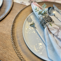 Discover the secret to an effortlessly elegant table setting with our taupe Lexington Placemats. These round vinyl wonders not only add a stylish touch to any meal but also promise a quick cleanup with their wipeable surface. Perfect as a Mother's Day gift, they're a chic, practical choice for the discerning hostess.