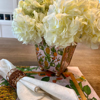 Make a statement with our Enameled Square Cachepot Planter, a playful yet practical table centerpiece. Decked out in a vibrant palette and a fruity motif of pineapples, limes, and oranges, this cachepot is trimmed in gold for that extra sparkle. Whether you're looking to brighten up your office desk, kitchen counter, or dining table, it offers a splash of spring and summer all year round. Versatile and visually stunning, it’s the centerpiece that brings your tablescape ideas to life.