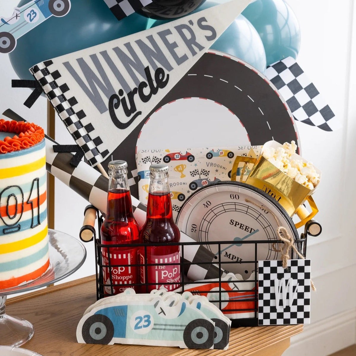 Winners Circle-themed car party decor with speedometer plates and racing-inspired birthday party decorations.