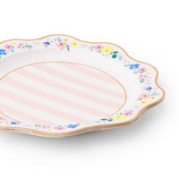 Angled stack of multicolor floral scalloped paper dinner plates with pink stripe center and gold foil rim on white background