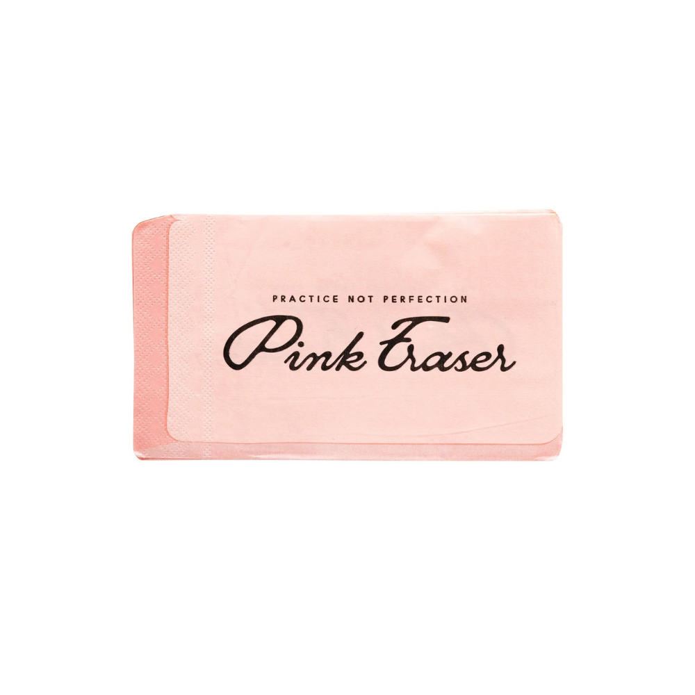 Unwrapped eraser-shaped napkin showing the full pink design and “Practice Not Perfection” phrase in black script.