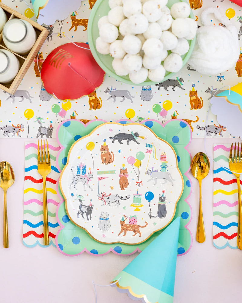Colorful place setting featuring the Cat Party Plate on layered chargers with gold cutlery and party hats.