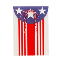 Americana-themed paper treat bags for children’s party favors, decorated with bold stripes, stars, and a twine closure.
