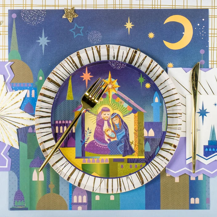 Decorative plate with nativity scene design, fork, and knife on a festive background