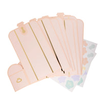 Flat lay image showcasing unfolded soft pink treasure box treat holders and coordinating pastel seashell stickers, ready for assembly.