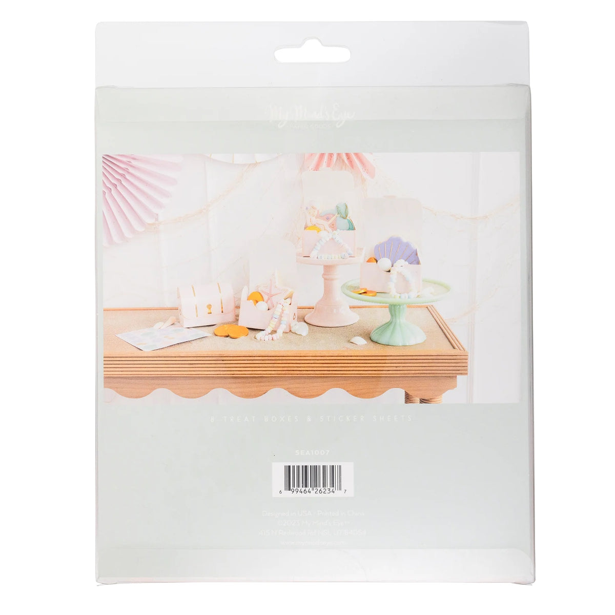 Back view of packaging showing adorable mermaid-themed treat boxes displayed with cookies and candy jewelry on pastel-colored cake stands.