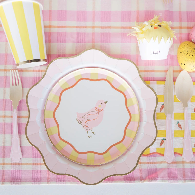 A vibrant Easter tablescape with Sweet Carrot Easter napkins adding a pop of cheerful spring color, complementing striped cups, floral arrangements, and adorable themed decor.