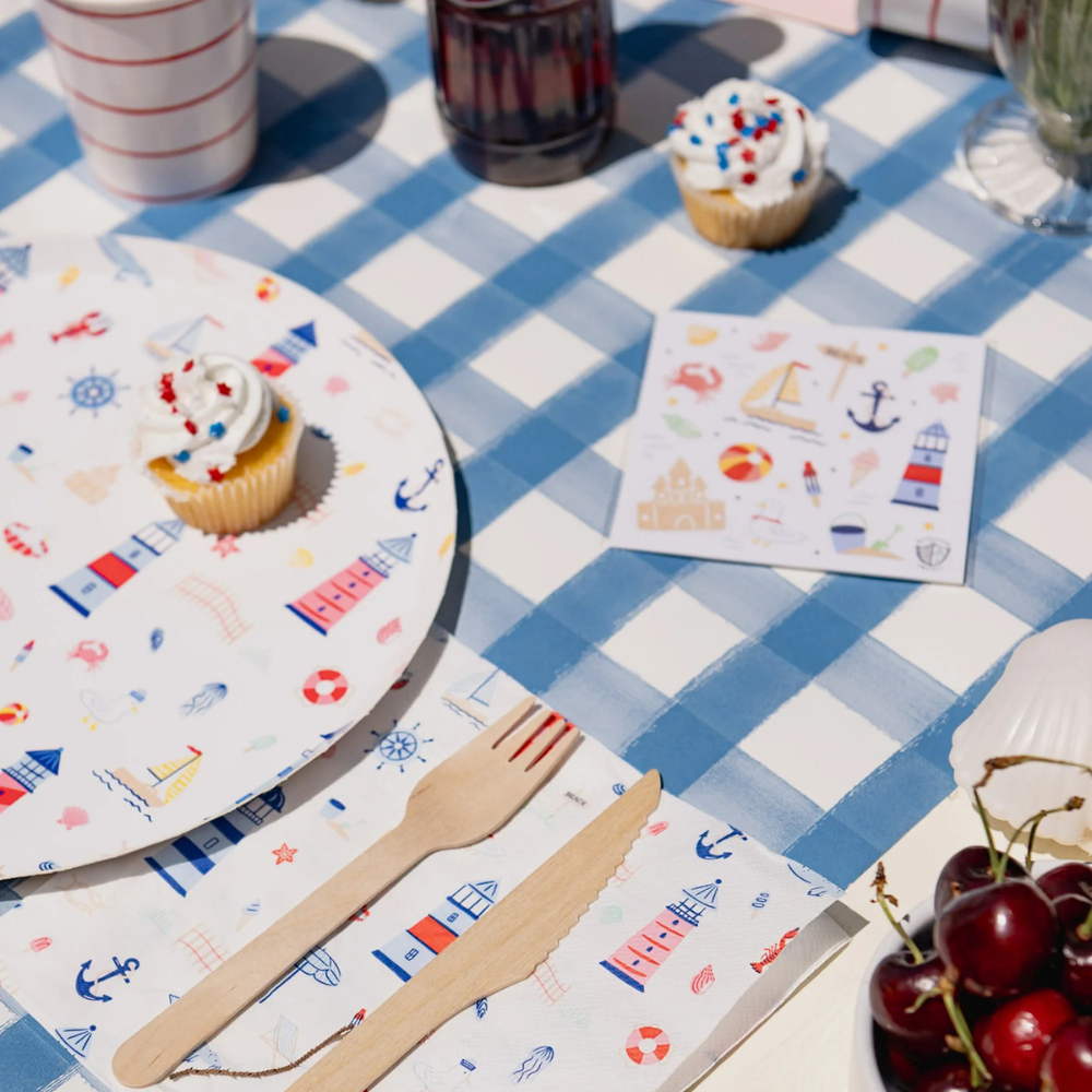 Lifestyle image showing Seaside Stickers placed on a blue gingham party table with coordinating lighthouse-themed tableware.