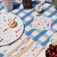 Lifestyle image showing Seaside Stickers placed on a blue gingham party table with coordinating lighthouse-themed tableware.