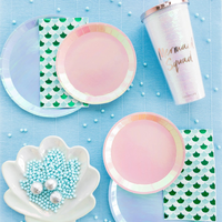 Flat lay of Shell Yeah Guest Napkins with pastel party decor, including mermaid shell plates and a “Mermaid Squad” tumbler.