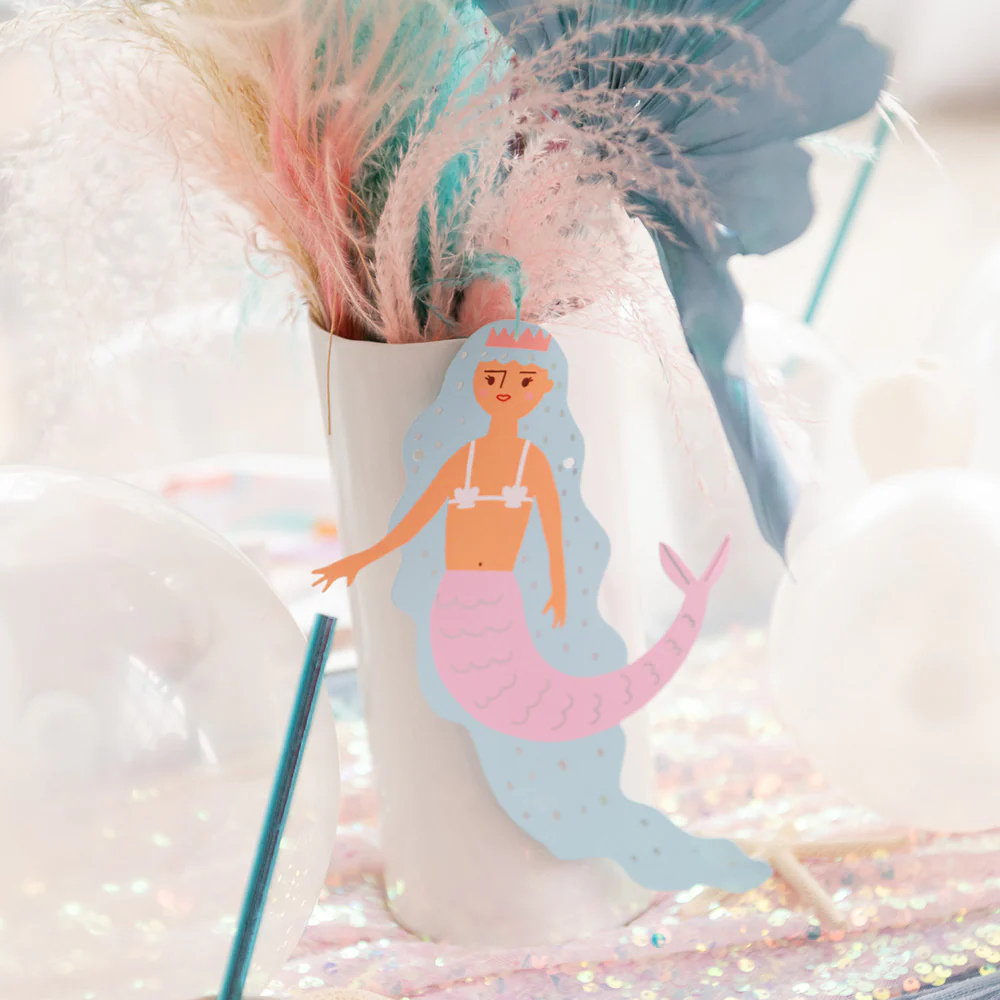 Close-up of a mermaid die-cut from the Under the Sea Thingamajigs, taped to a white vase with pastel feather bouquet.