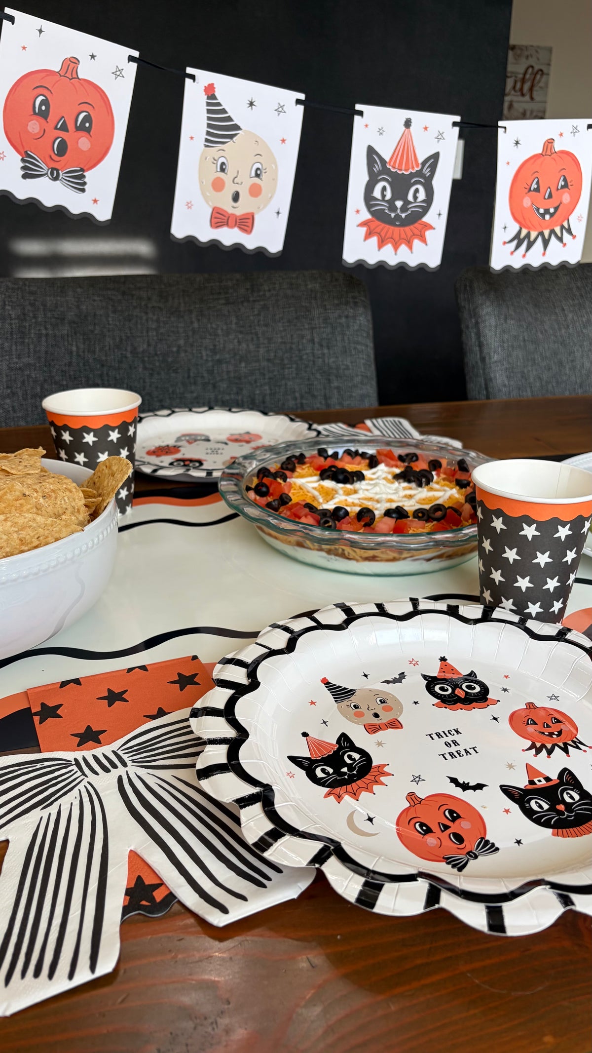 Angled view of the hanging Spooky House Halloween countdown calendar showing the black ghost roof, 31 numbered pockets, and Halloween icons on a cream canvas body