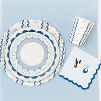 Overhead flat lay of blue ribbon tableware set with a scalloped stork napkin