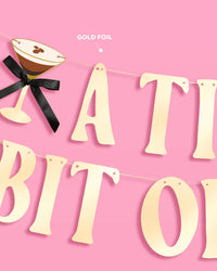 Gold foil banner detail showing espresso martini icon with black bow and partial lettering, labeled "gold foil"