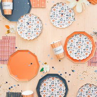 Floral centerpiece surrounded by four patterned dessert plates and plaid guest towels.
