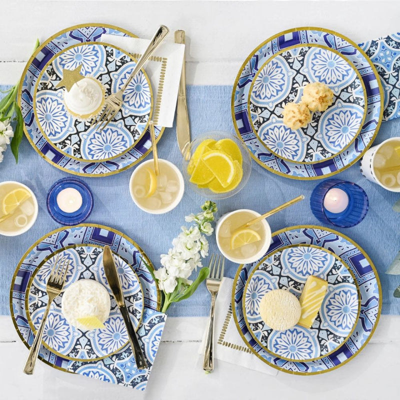 Mediterranean party table with blue tile dessert plates and summer drinks.
