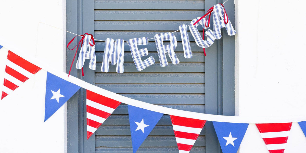 Navy ticking stripe America banner hung on blue shutters above red white and blue star pennant bunting
