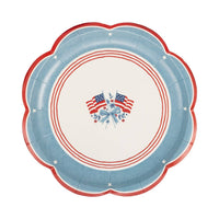 Single American flag scalloped paper plate showing full heritage illustration — crossed flags, blue floral ribbon, chambray border, white stars, and red scalloped rim on white background