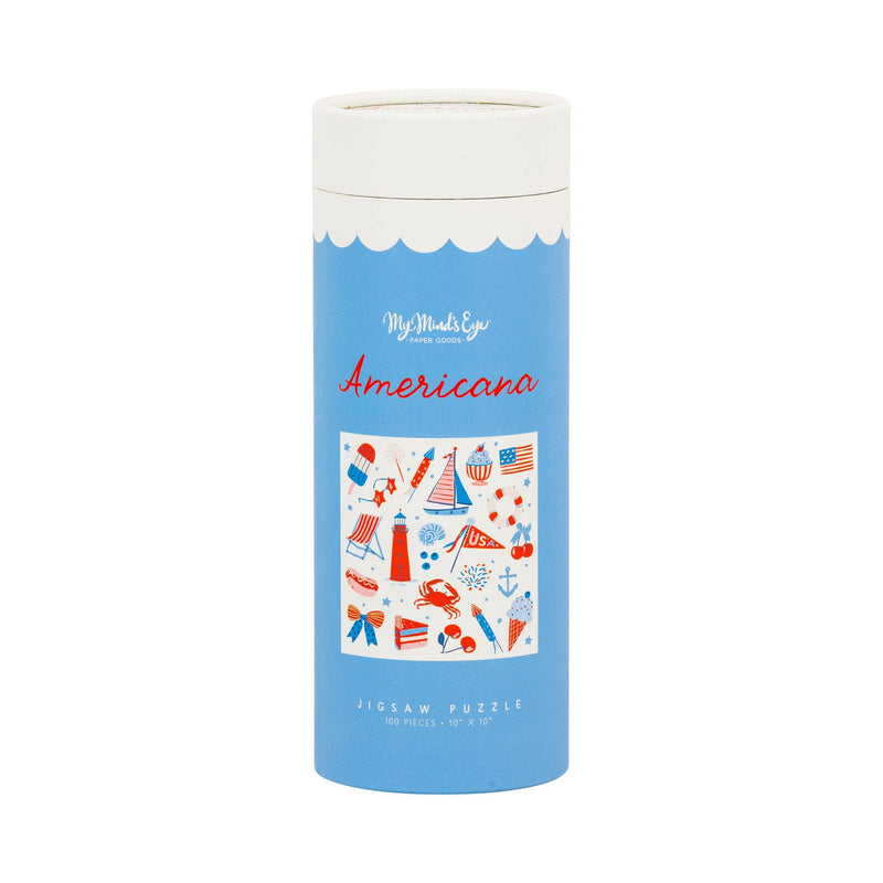 Front of a light blue gift tube labeled Americana Jigsaw Puzzle 100 Pieces with illustrated label showing red cream and blue Americana and summer icons including sailboats, lighthouses, popsicles, American flags, firecrackers, and hot dogs