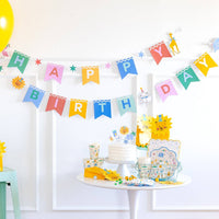 Animal party birthday setup featuring banner, plates, cups, and decorations.