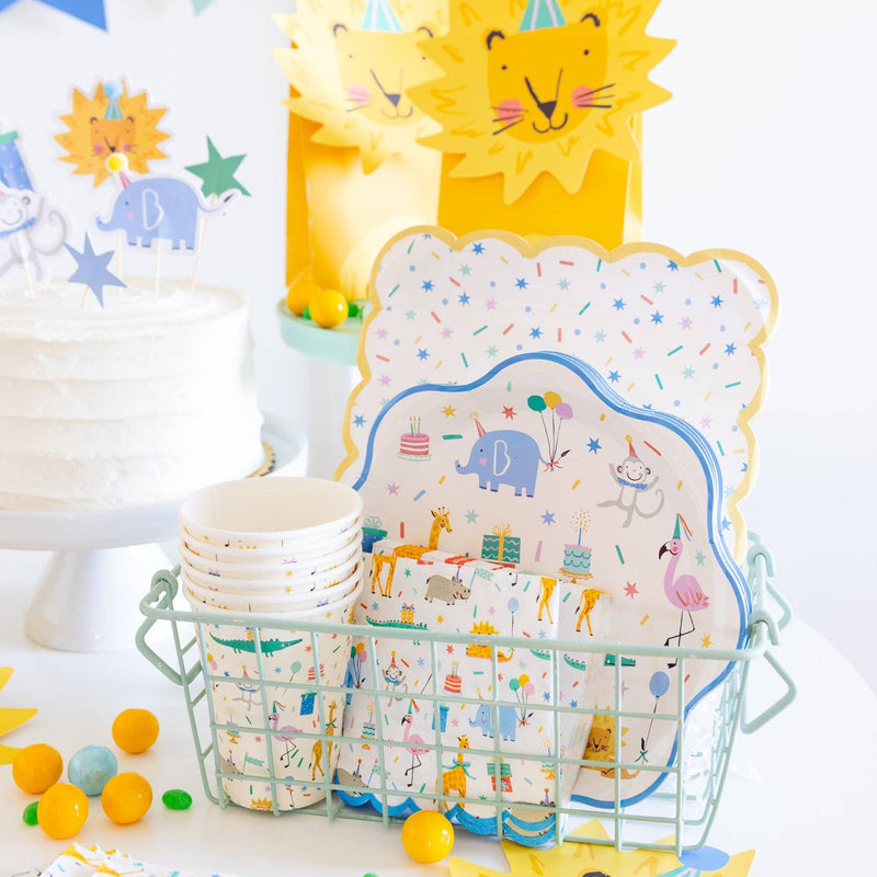 Animal party napkins displayed in a basket with matching plates and cups.