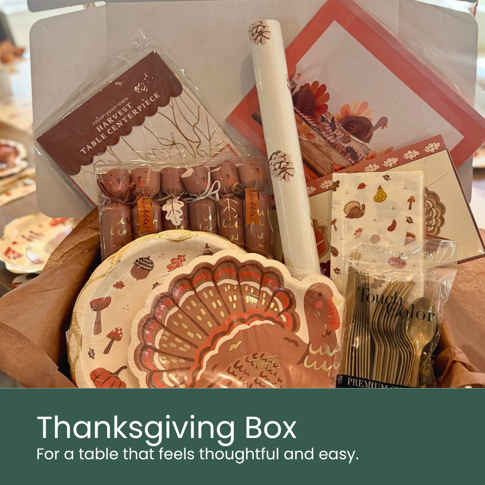 Moment & Co's Thanksgiving Party Kit, featuring turkey shaped plates, turkey party crackers, gold cutlery, harvest icon napkins, pinecone table runner, and turkey fan.
