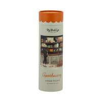 Apothecary Halloween jigsaw puzzle tube showing a witch reaching for a bottle in a shop full of potion jars, skull and cobwebs
