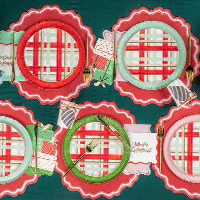 Overhead view of four place settings using assorted dotted plates in red, green, pink, and mint.