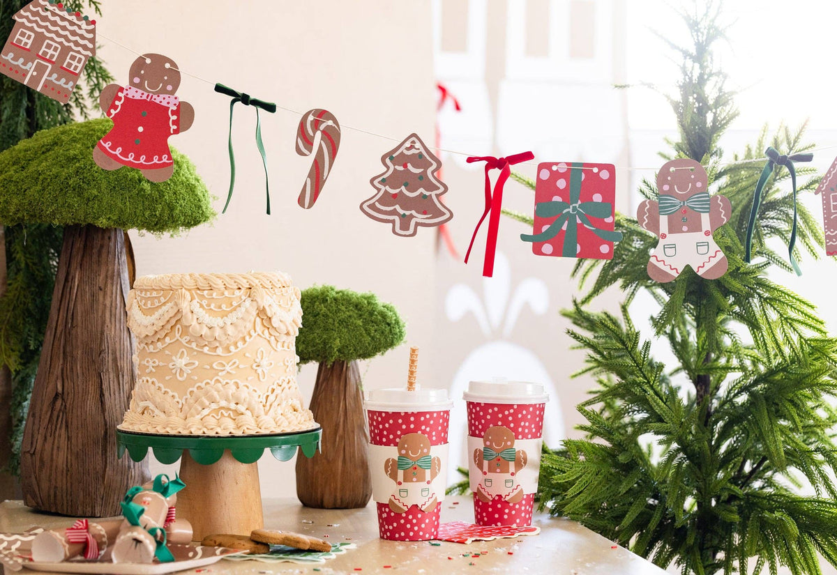 Gingerbread Banner hung above a dessert table with cake and cups.