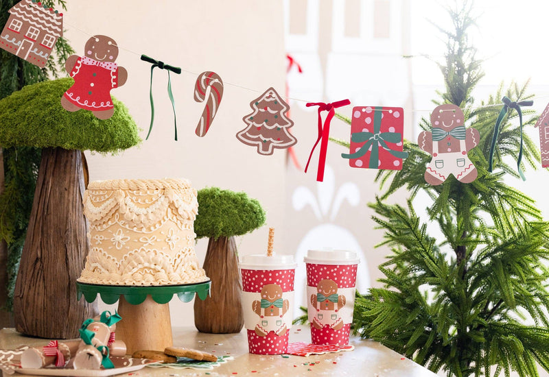 Gingerbread Banner hung above a dessert table with cake and cups.