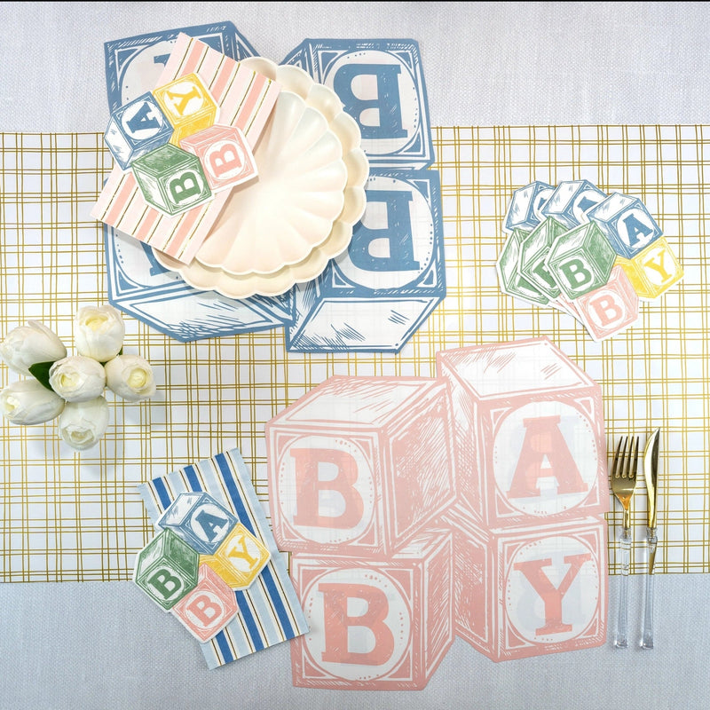 Tablescape with blue and pink Baby Blocks paper placemats, coordinating plates and napkins—styled baby shower table decorations.