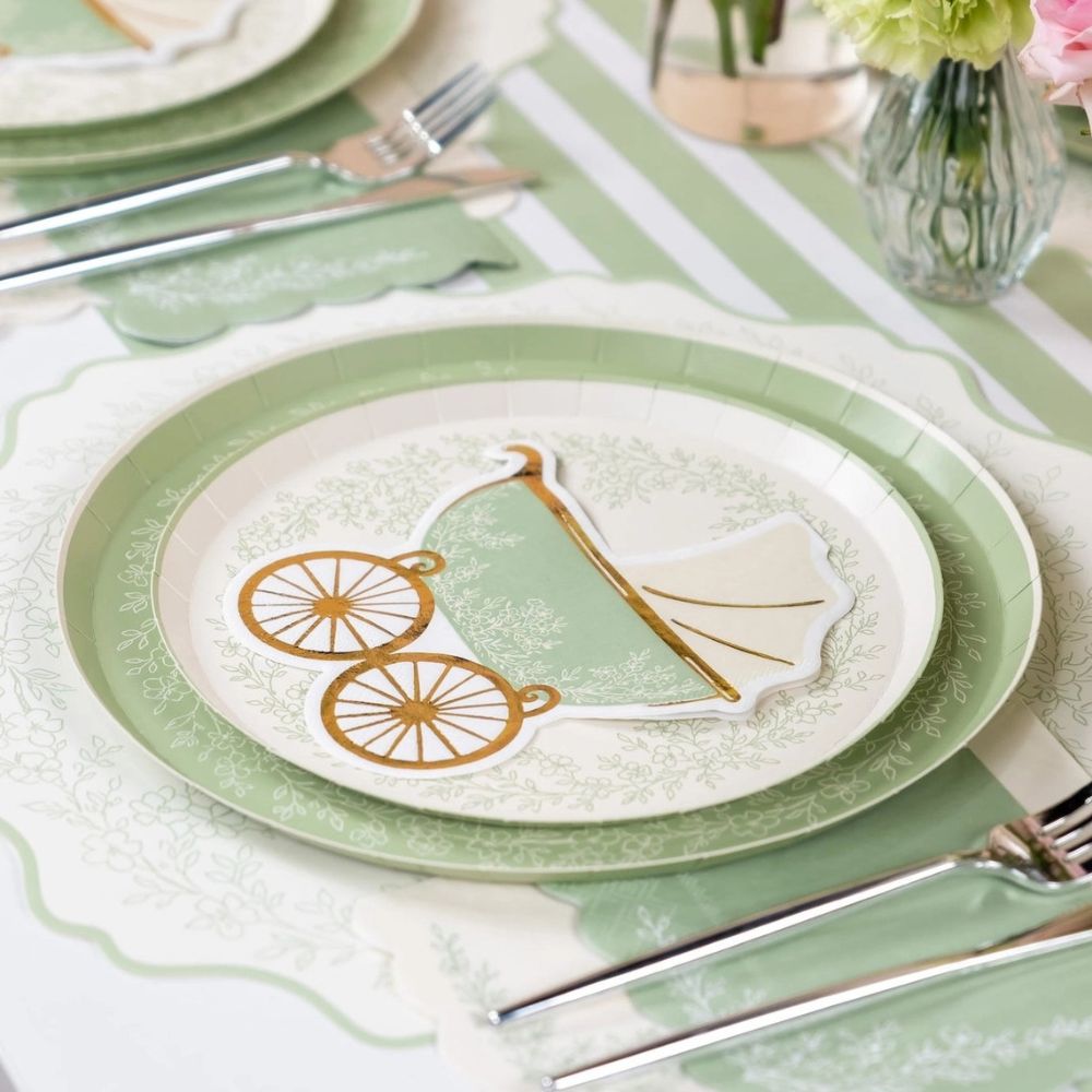 baby carriage cocktail napkin on layered tableware.