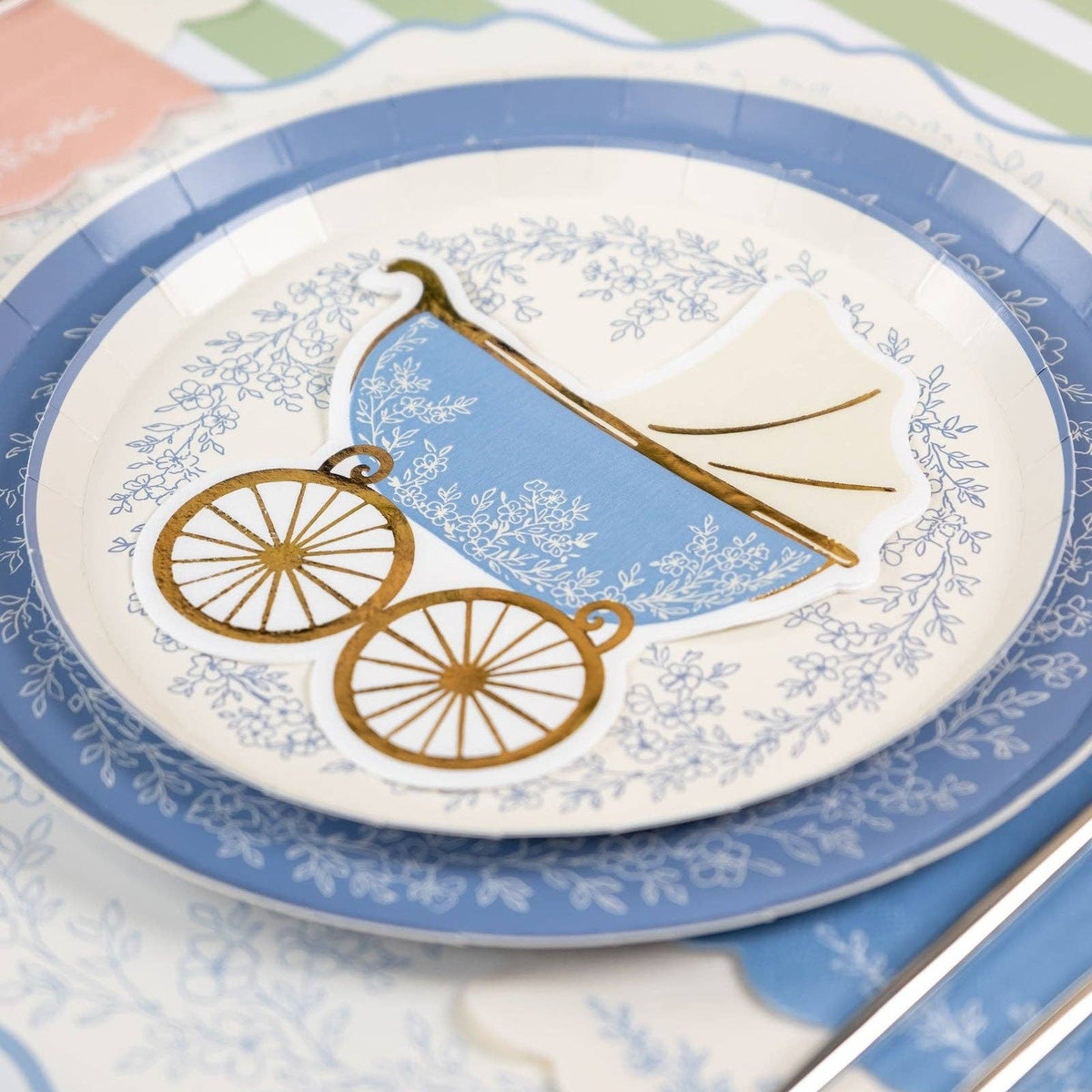 stroller shaped baby shower napkin on blue floral plate

